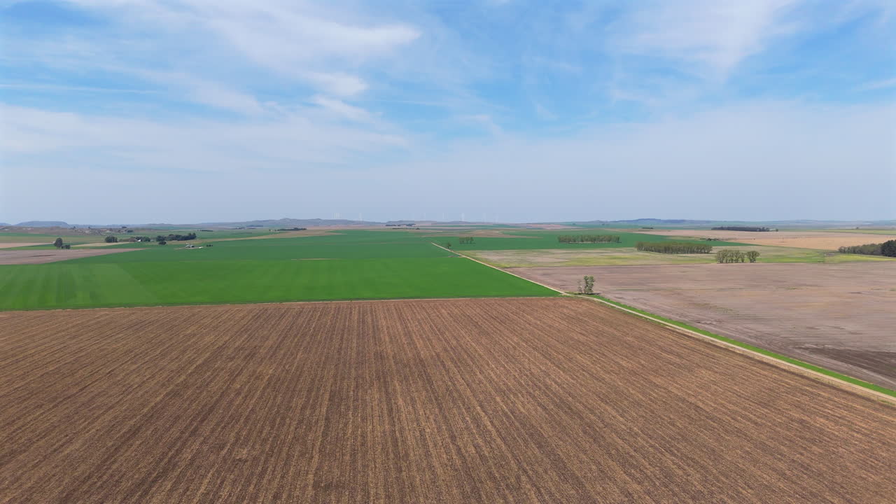Luftaufnahme einer Agrarlandschaft mit grünen und braunen Feldern, Textfreiraum und Zeitlupe