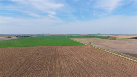 aerial shot of a agricultural landscape with green and brown fields, copy space and slow motion