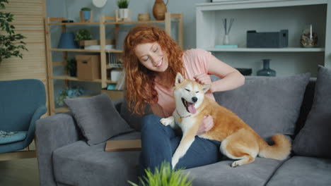 Woman and her Shiba Inu dog on a sofa