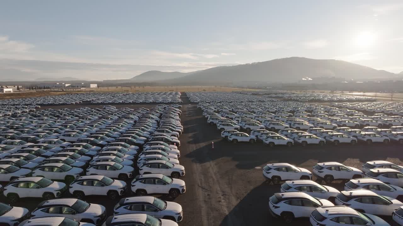 Aerial forward motion above full parking lot with brand new cars