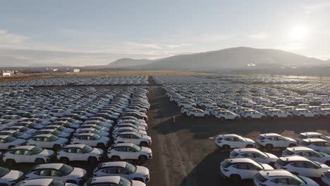 aerial forward motion above full parking lot with brand new cars