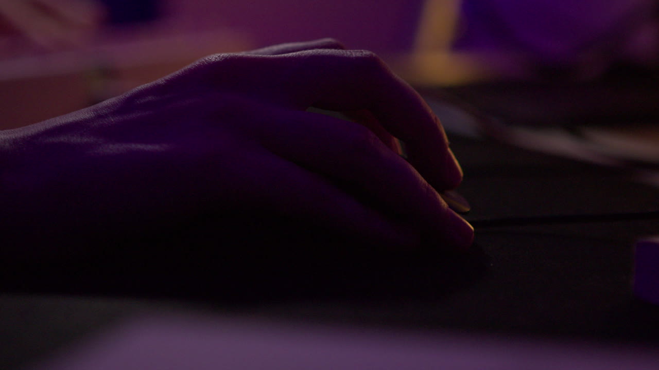 Hand holding a mouse in low light