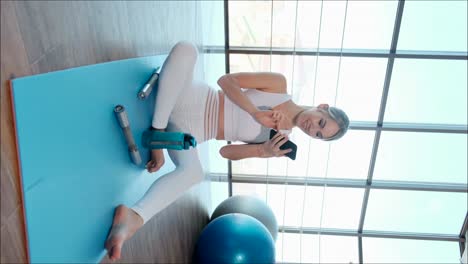 young sporty girl showing exercises online using smartphone young sporty girl showing exercises online using smartphone the concept of fitness and healthy lifestyle
