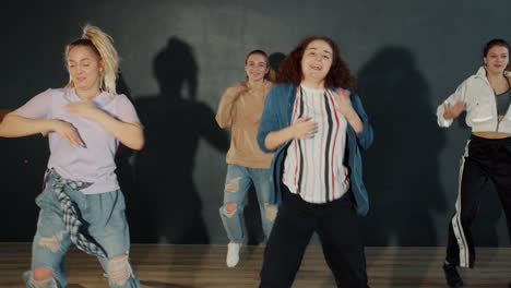 teenage girls performing a dance routine in a studio