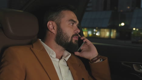 business man having phone call in backseat