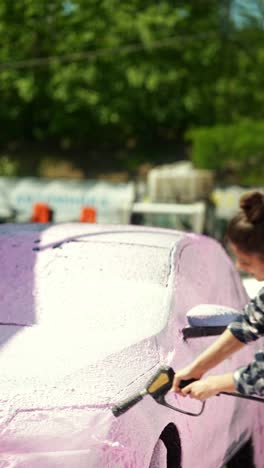 woman washing a car with foam