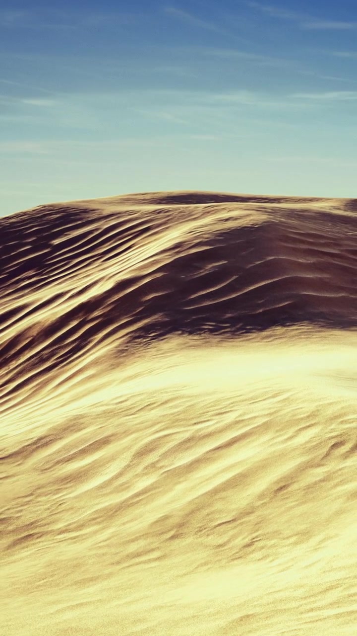 Dune di sabbia dorata che si modellano sotto un cielo luminoso in un paesaggio desertico.