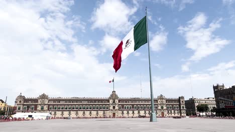 Toma-En-Cámara-Lenta-De-La-Bandera-Mexicana-Ondeando-En-El-Zócalo-Frente-Al-Palacio-Nacional-Al-Mediodía