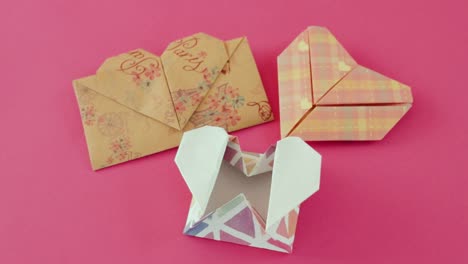 sobres en forma de corazón plegados de papel origami en papel rosado
