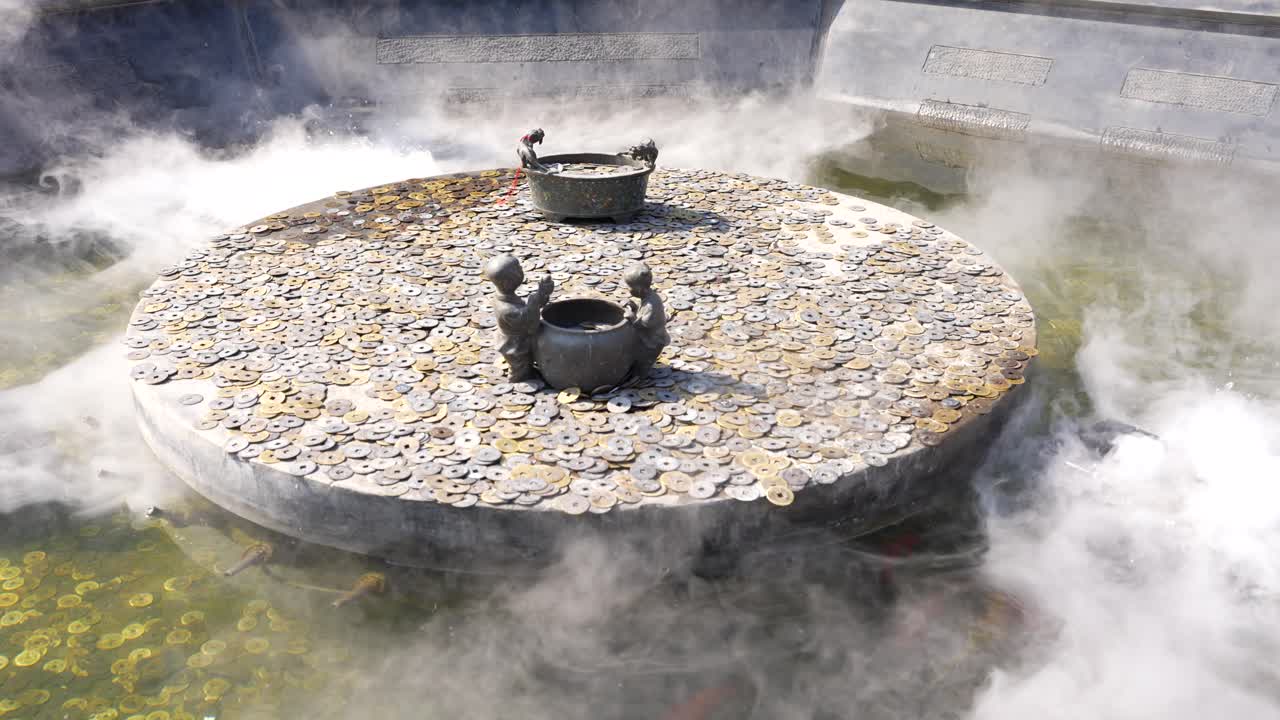 네불라이제이션으로 동전으로 인 돌 바를 가진 불교 연못