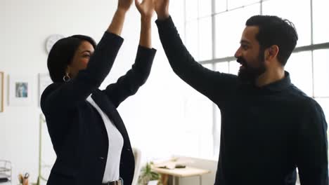 two coworkers share a joyful moment in a modern office, high-fiving each other to celebrate their recent achievement while enjoying the bright atmosphere.