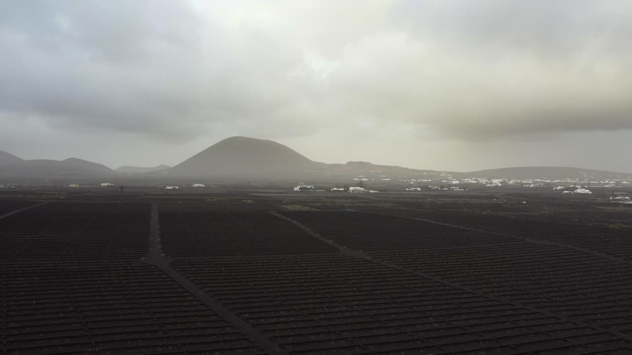 Aerial landscape of black soil and ash on the ground near a volcano