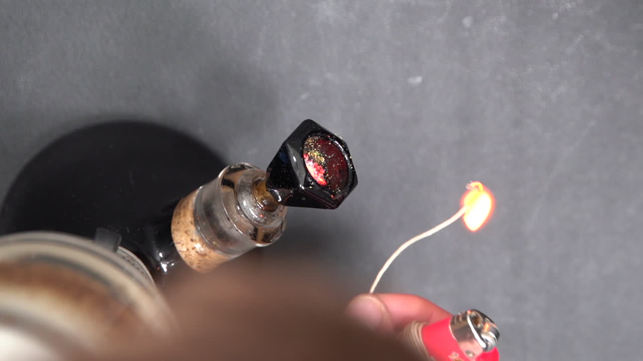 Man Lighting A Glass Bong With Dried Cannabis Using A Lighter - Unhealthy Lifestyle - top down shot
