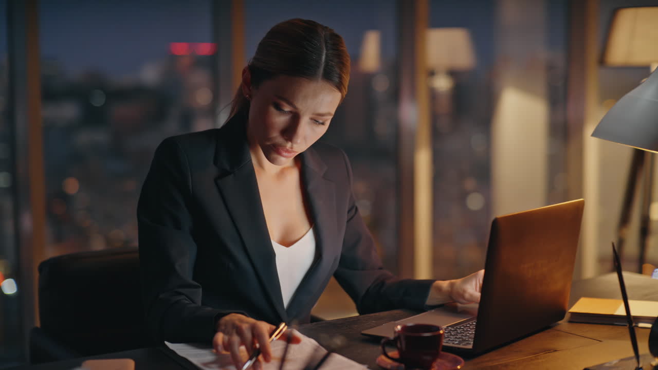 緊張した女性が財務報告書を分析して遅くまで働いています ストレスを感じたマネージャーがチェックしています