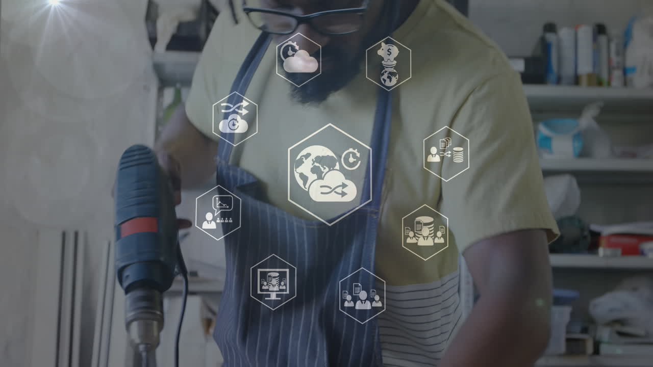 animación de iconos digitales sobre carpintero afroamericano usando una máquina de perforación en el taller.