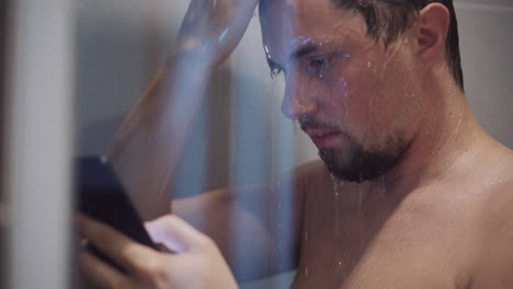 man using phone in shower