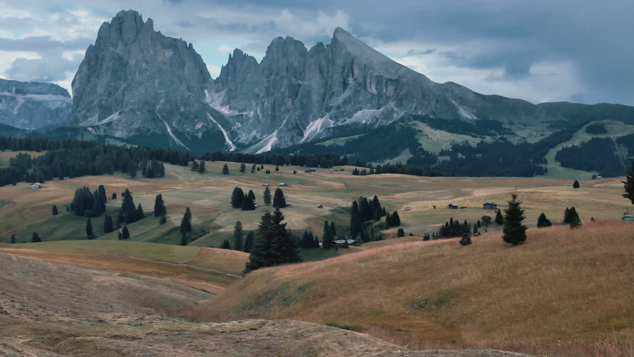 Tourist enjoying breathtaking view of Sassolungo mountain range in Alpe di Siusi, Dolomites, Italy. Slow motion