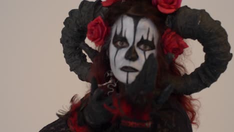 catrina cosplay girl looking to the camera and calling for you in a light background, medium close up