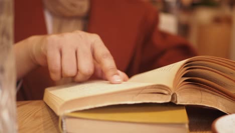 mujer leyendo un libro en un café
