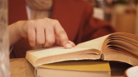 woman reading a book in a cafe