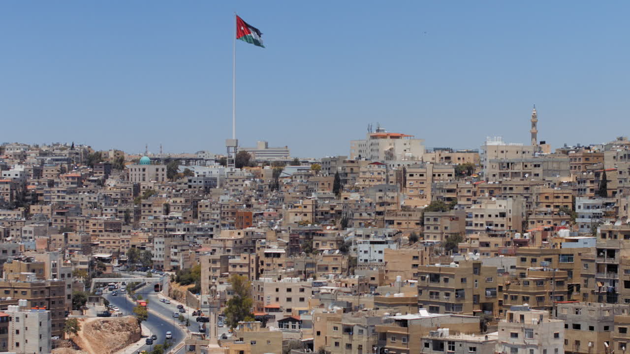 Panorama of the city of Amman, Jordan with flag view from Jabal Al Qal'a, the Citadel of Amman. Zoom. 4K