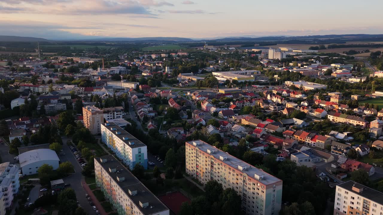 Aerial drone view of the town of Svitavy during a calm evening. Residential apartment blocks are nestled in a peaceful neighborhood, with soft evening light casting long shadows over the quiet streets