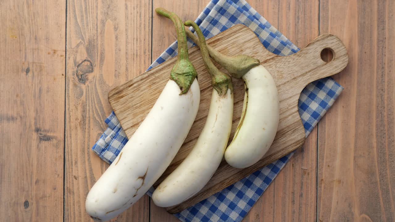 berenjenas blancas en una tabla de cortar de madera