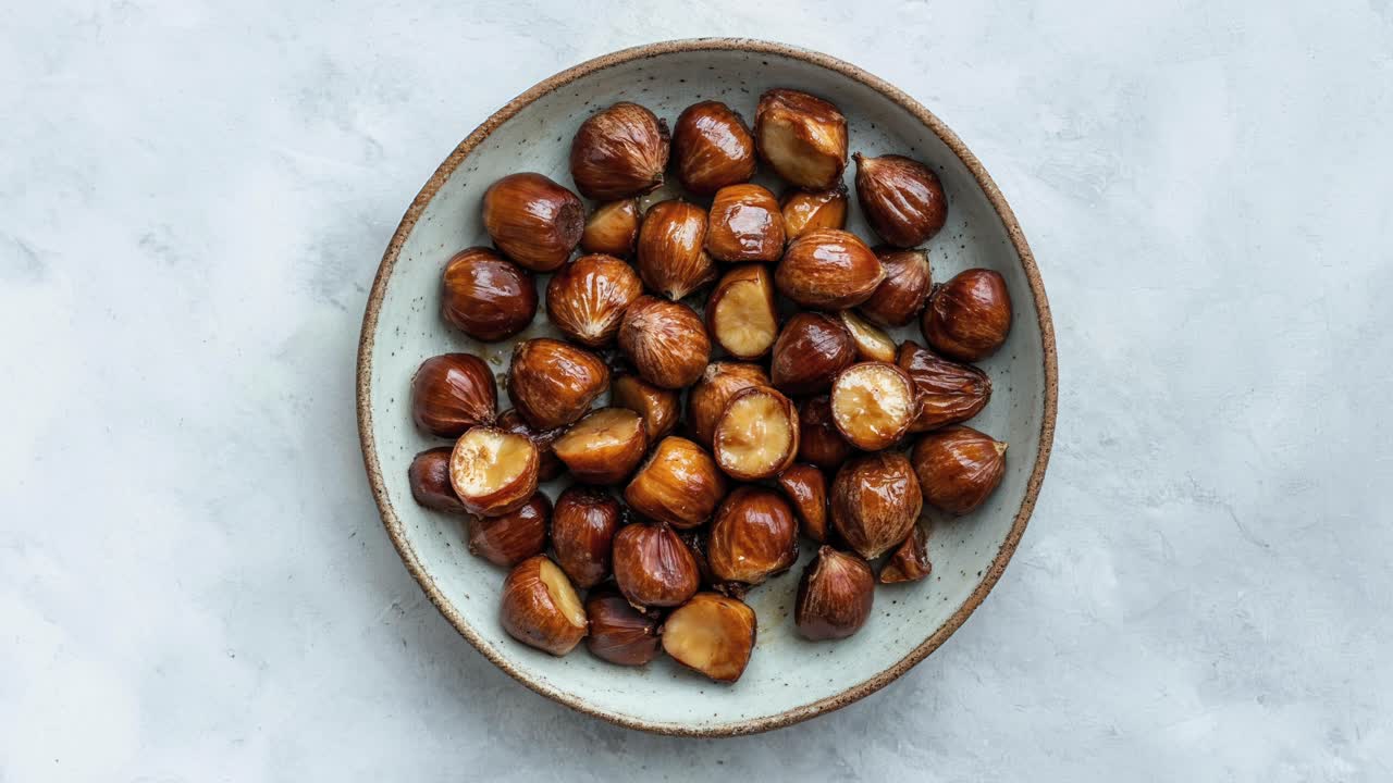 Ciotola di castagne arrostite su sfondo di piatto rustico
