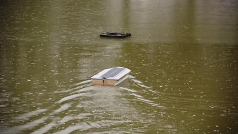 Un-Barco-Con-Panel-Solar-Controlado-Remotamente-Impulsado-Por-Panel-Solar-Fotovoltaico-Navega-Con-Gracia-En-Un-Estanque-Mientras-Llueve