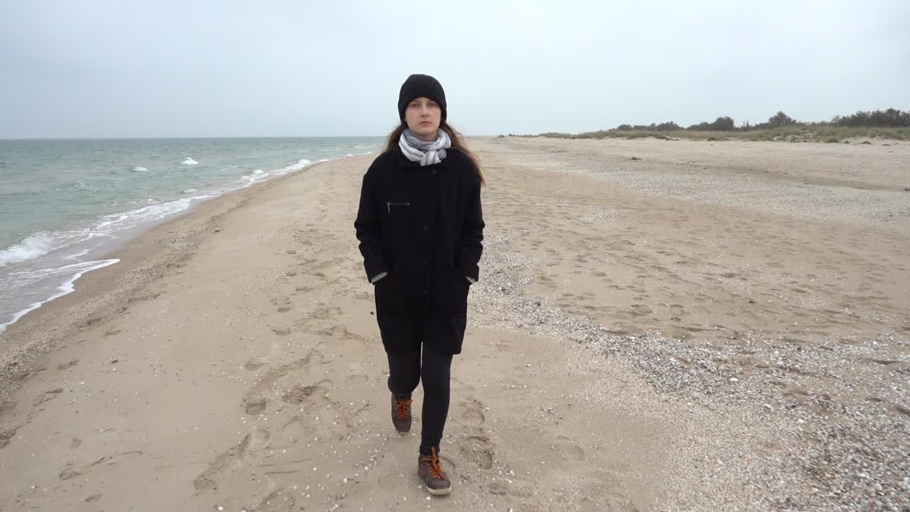 The girl walks on the beach. Shooting on the beach