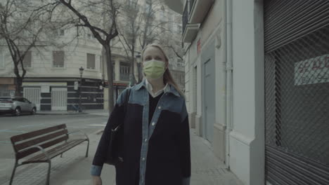 woman pedestrian in mask walking in the city