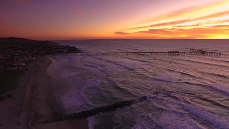 Cinematic-aerial-view-of-kitesurf-sailing-at-sunset-with-colorful-sky-in-background,-San-Diego