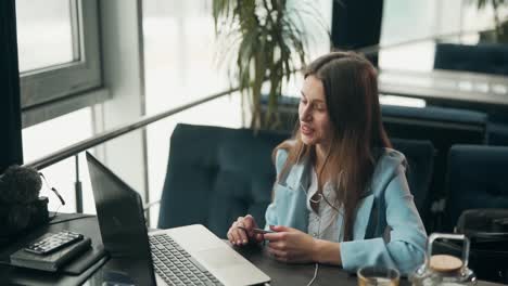 close-up-portrait-Young-stylish-girl-puts-on-headphones-and-communicates-online-on-a-laptop