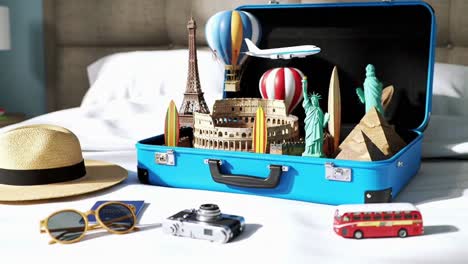 blue suitcase and travel accessories on a hotel bed