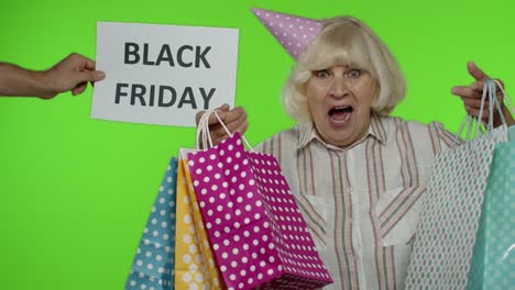 advertisement inscription black friday appears next to joyful grandmother with shopping bags