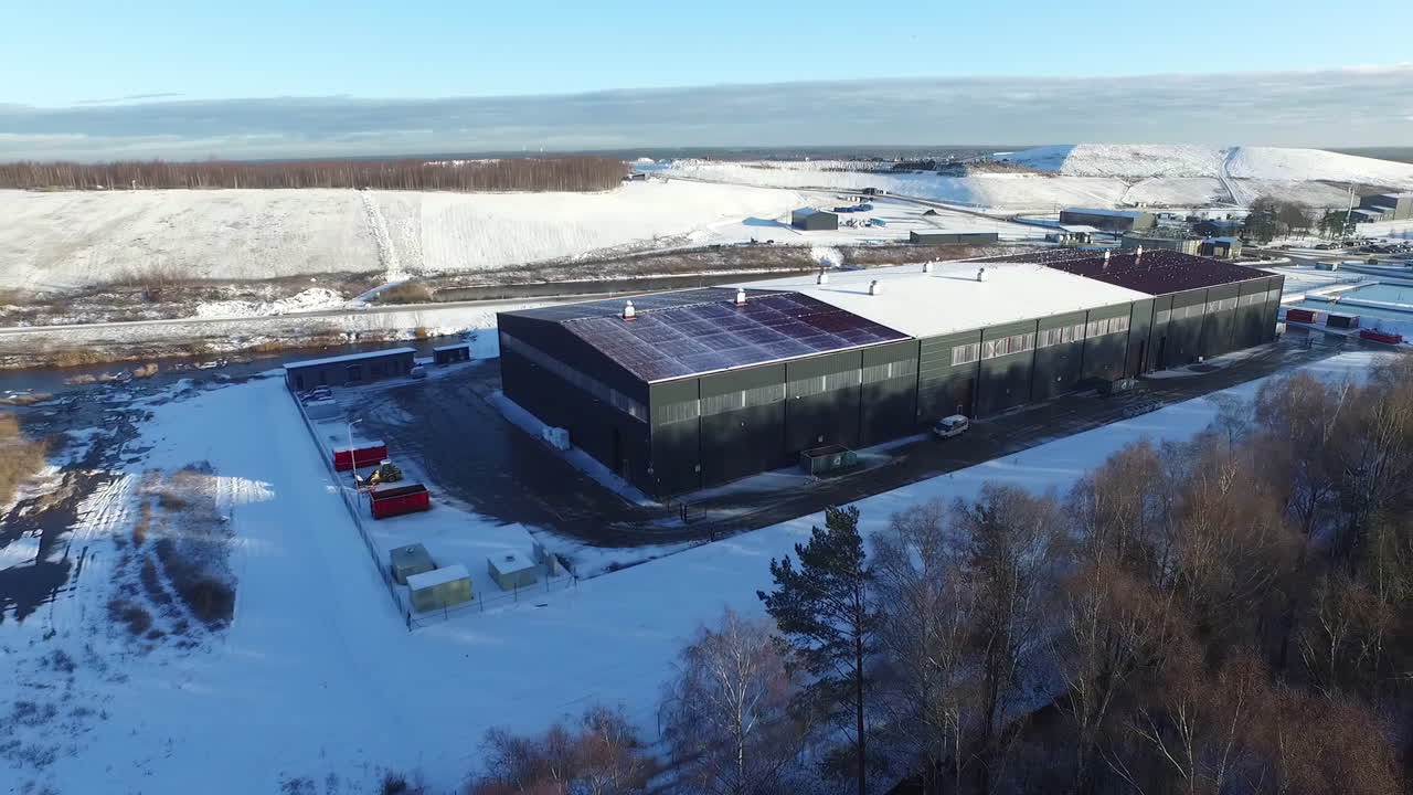 Luftfoto af stor industriel logistikterminal med lagerbygning om vinteren, droneoptagelse