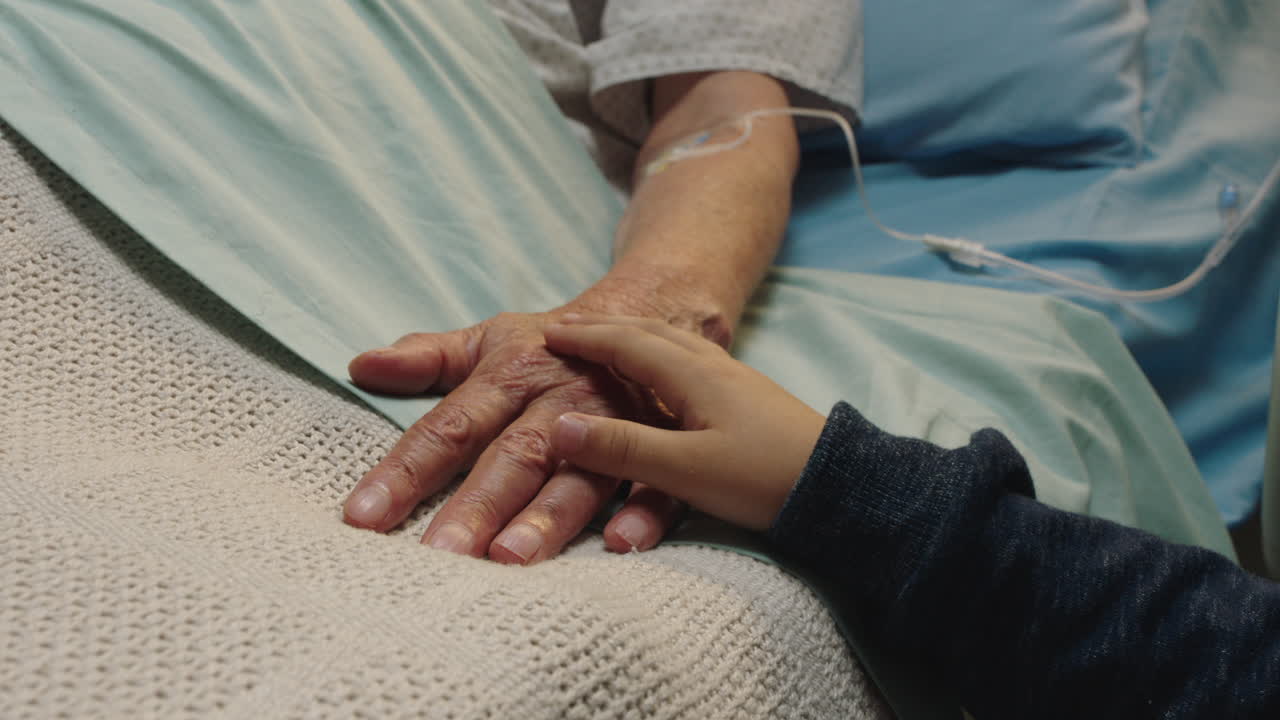 niño pequeño tocando la mano de la abuela acostada en la cama del hospital niño mostrando afecto al lado de la cama para la abuela recuperándose de la enfermedad apoyo de atención médica