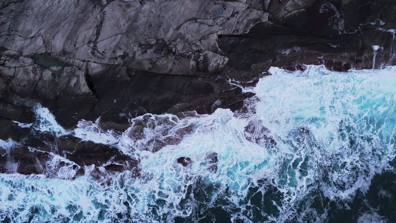 Le onde si infrangono contro le coste rocciose a Tungeneset Beach, creando una scena drammatica.