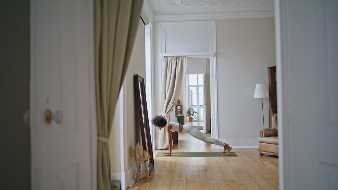 mujer de entrenamiento flexible casa de yoga. mujer afroamericana practicando gimnasia