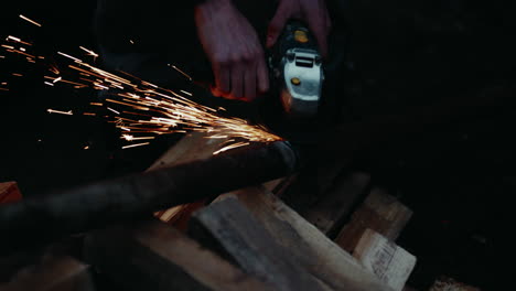 operating an angle grinder to remove the imperfections of welding tubes together