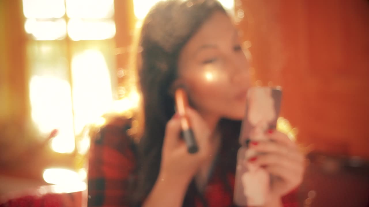 카메라가 돌리에 장착되어 있는 동안 그녀의 화장을 하고 있는 아름다운 칠레 여성