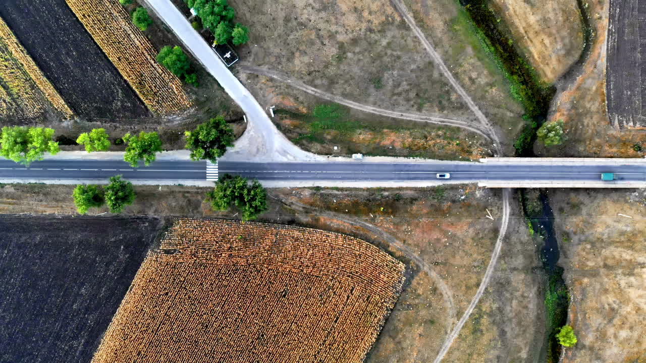 Aerial drone view of a road with moving car in highland. Green fields and hills from north part of Moldova