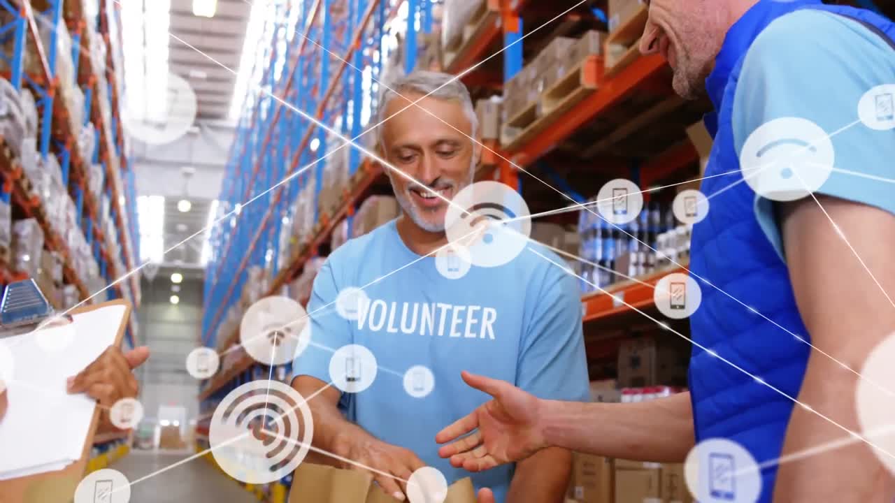 animación de la red de iconos en el supervisor masculino caucásico y el voluntario estrechando la mano en el almacén.