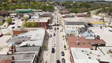 Aerial-descend-flyover-downtown-of-Grimsby-during-many-cars-passing-road-in-summer,Canada
