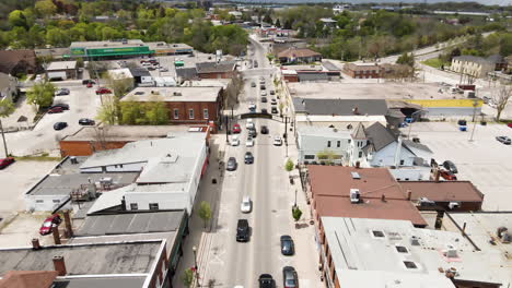 aerial descend flyover downtown of grimsby during many cars passing road in summer,canada