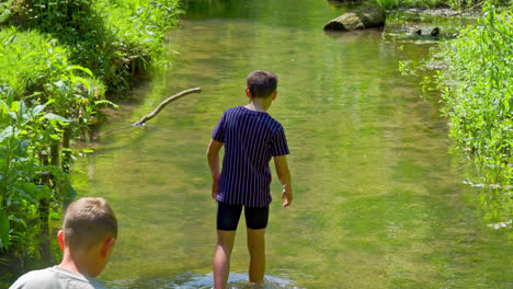 a uk summer park hosts a boy's play and walks, with people enjoying the stream, lovely picnics, and the woodland draw of hubbard's hills