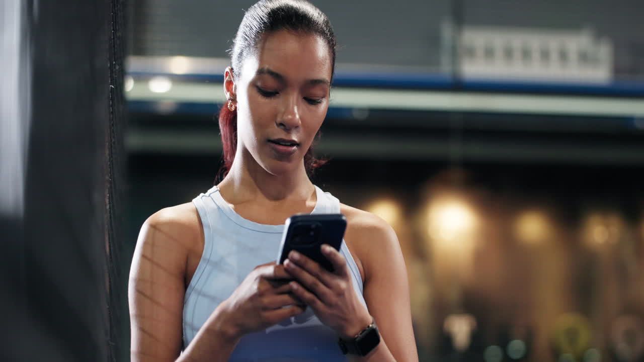 Woman using phone at the gym