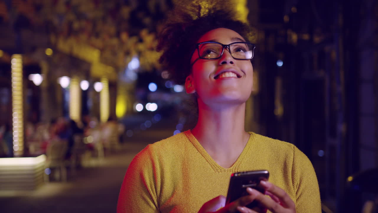 mujer de la ciudad nocturna usando su teléfono inteligente