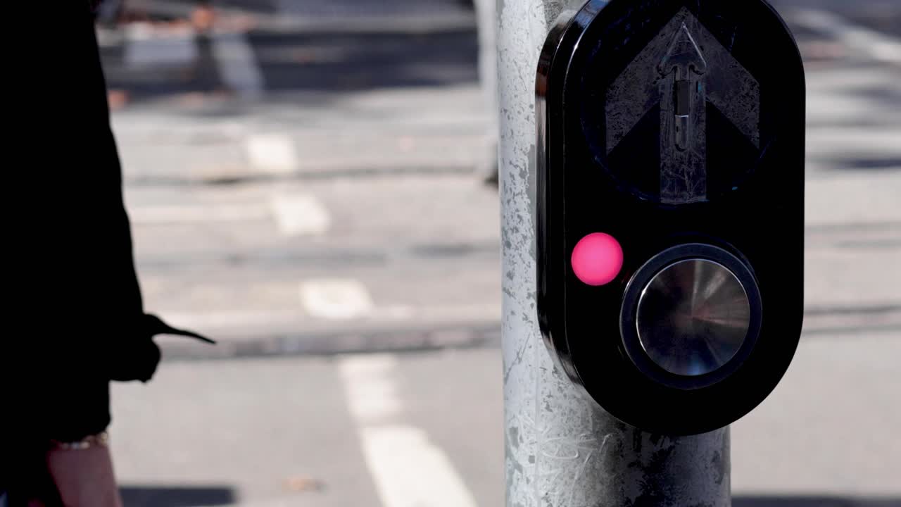 persona presionando el botón en el semáforo