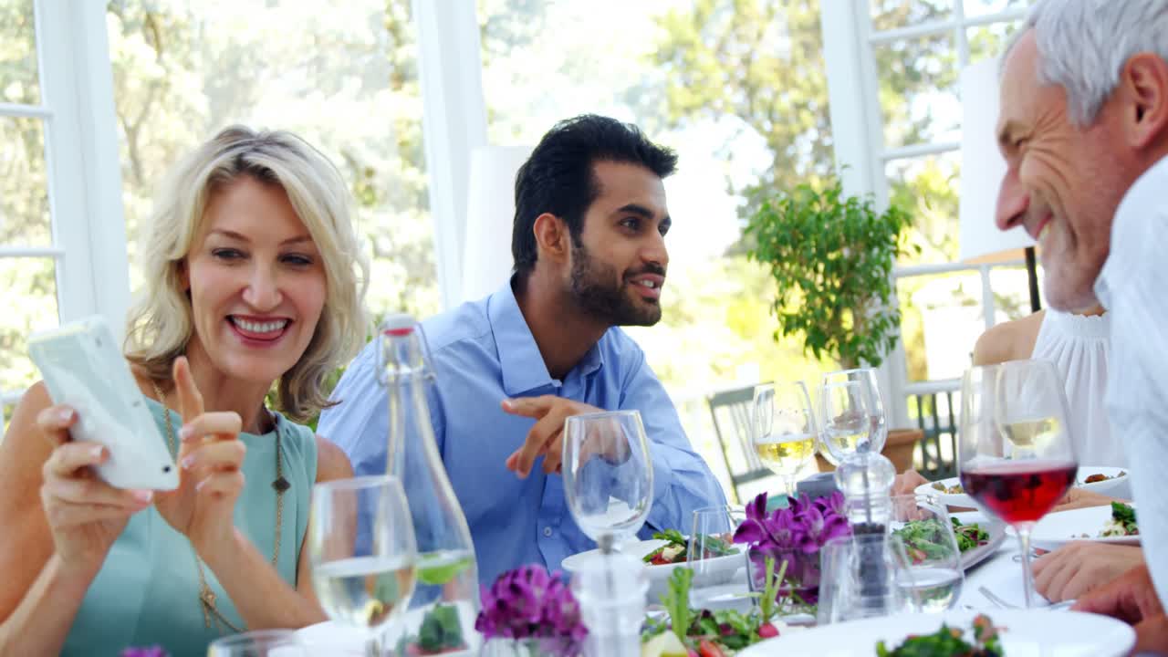 amigos usando tableta digital mientras comen en un restaurante